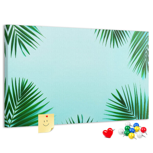 Pizarra de corcho con diseño de hojas tropicales sobre fondo azul