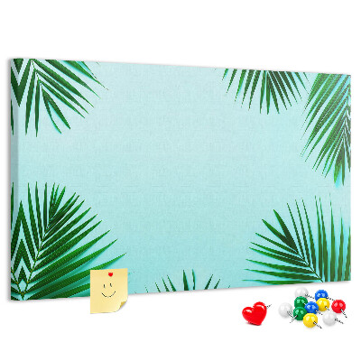 Pizarra de corcho con diseño de hojas tropicales sobre fondo azul