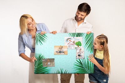 Pizarra de corcho con diseño de hojas tropicales sobre fondo azul