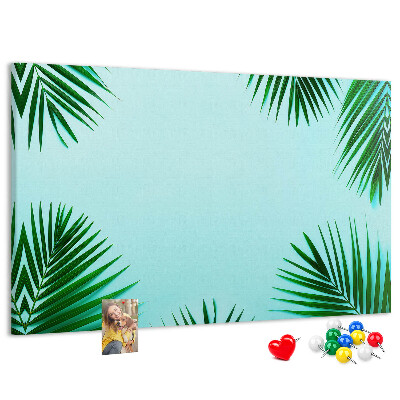 Pizarra de corcho con diseño de hojas tropicales sobre fondo azul
