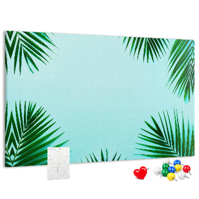 Pizarra de corcho con diseño de hojas tropicales sobre fondo azul