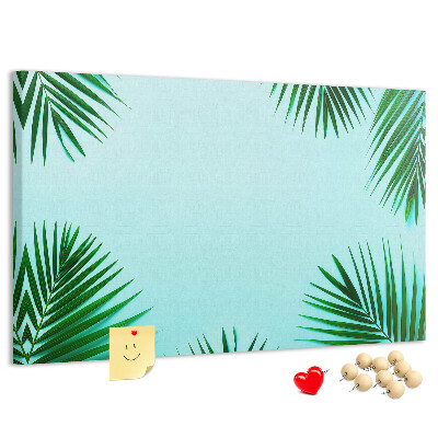 Pizarra de corcho con diseño de hojas tropicales sobre fondo azul