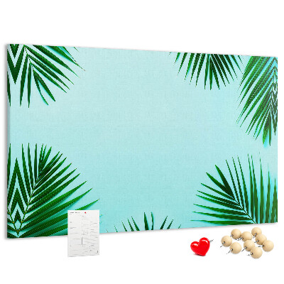 Pizarra de corcho con diseño de hojas tropicales sobre fondo azul