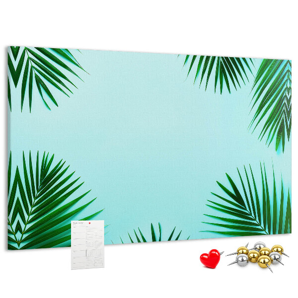 Pizarra de corcho con diseño de hojas tropicales sobre fondo azul