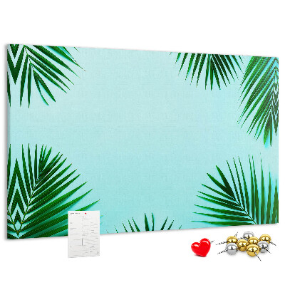 Pizarra de corcho con diseño de hojas tropicales sobre fondo azul
