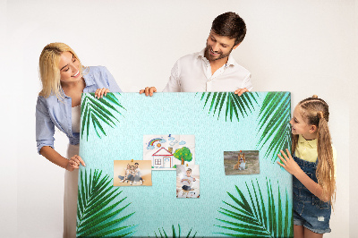 Pizarra de corcho con diseño de hojas tropicales sobre fondo azul