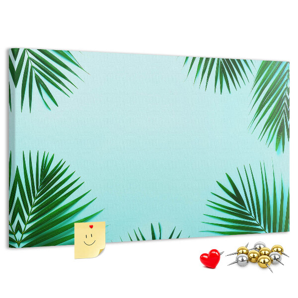 Pizarra de corcho con diseño de hojas tropicales sobre fondo azul