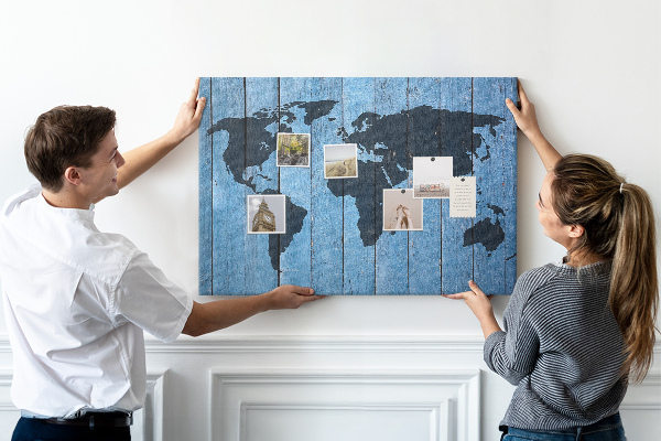 Pizarra de corcho con diseño de mapa del mundo sobre fondo de madera