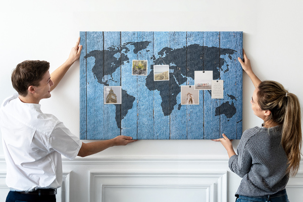 Pizarra de corcho con diseño de mapa del mundo sobre fondo de madera