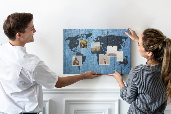 Pizarra de corcho con diseño de mapa del mundo sobre fondo de madera