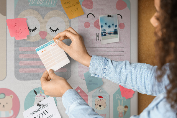 Pizarra de corcho con diseño de cuadernos coloridos y animales
