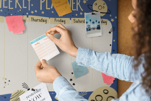 Tablero de corcho decorado planificador semanal con diseño de planetas y estrellas