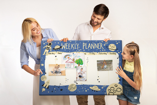 Tablero de corcho decorado planificador semanal con diseño de planetas y estrellas