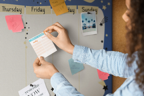 Tablero de corcho decorado planificador semanal con diseño de planetas y estrellas
