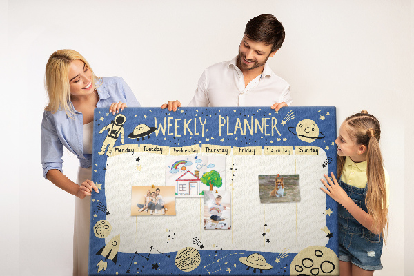 Tablero de corcho decorado planificador semanal con diseño de planetas y estrellas