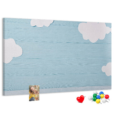 Pizarra de corcho con diseño de cielo con nubes sobre fondo de madera