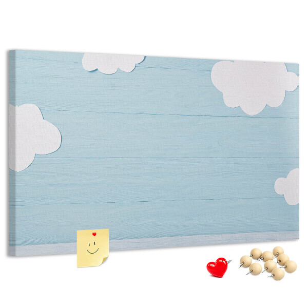 Pizarra de corcho con diseño de cielo con nubes sobre fondo de madera
