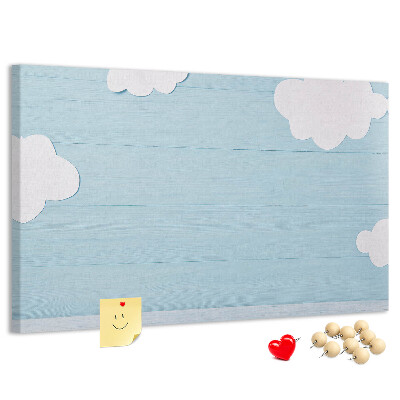 Pizarra de corcho con diseño de cielo con nubes sobre fondo de madera