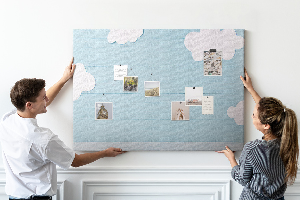 Pizarra de corcho con diseño de cielo con nubes sobre fondo de madera
