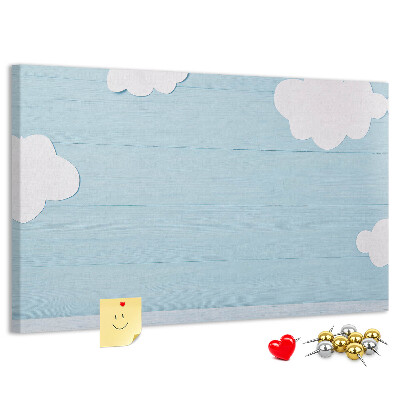 Pizarra de corcho con diseño de cielo con nubes sobre fondo de madera