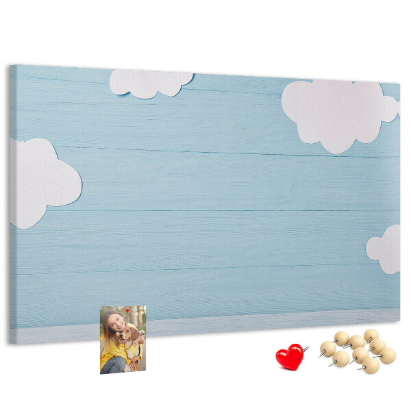 Pizarra de corcho con diseño de cielo con nubes sobre fondo de madera