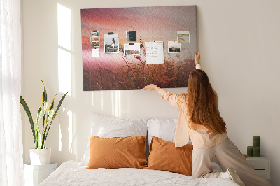 Tablero de anuncios con diseño de puesta de sol sobre un campo de hierba