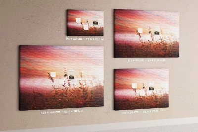 Tablero de anuncios con diseño de puesta de sol sobre un campo de hierba