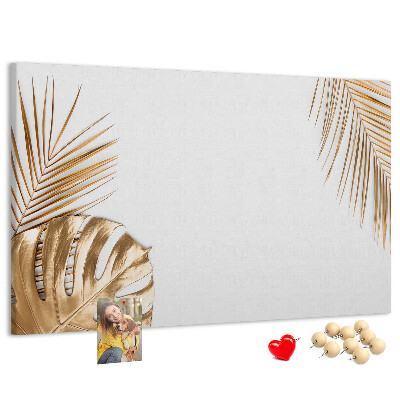 Pizarra de corcho con diseño de hojas doradas sobre fondo blanco