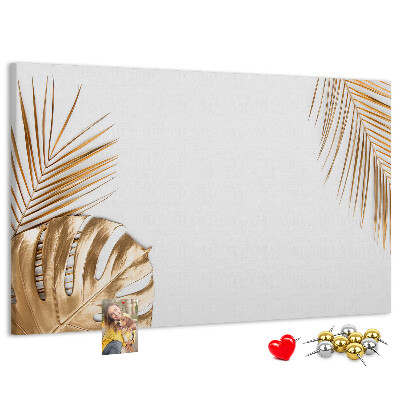 Pizarra de corcho con diseño de hojas doradas sobre fondo blanco