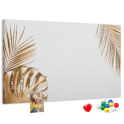 Pizarra de corcho con diseño de hojas doradas sobre fondo blanco