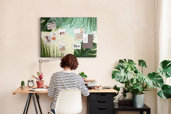 Tablero de corcho decorativo con diseño de hojas tropicales sobre fondo pastel