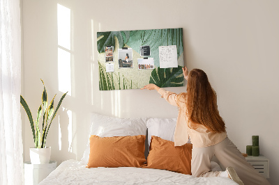 Tablero de corcho decorativo con diseño de hojas tropicales sobre fondo pastel