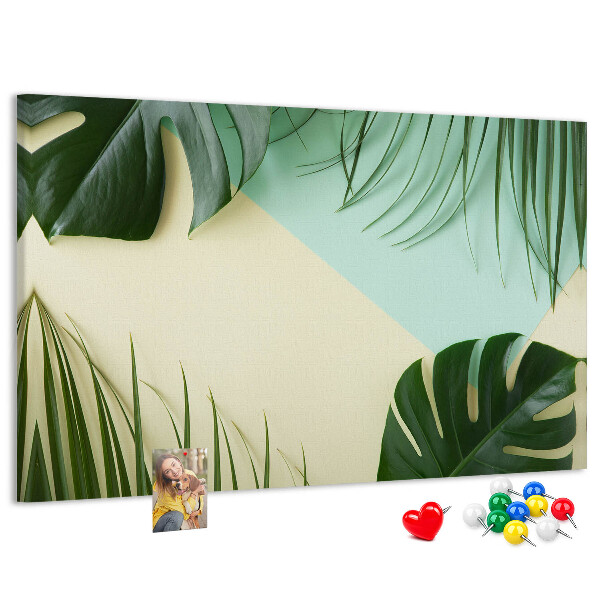 Tablero de corcho decorativo con diseño de hojas tropicales sobre fondo pastel