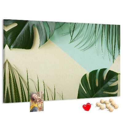 Tablero de corcho decorativo con diseño de hojas tropicales sobre fondo pastel