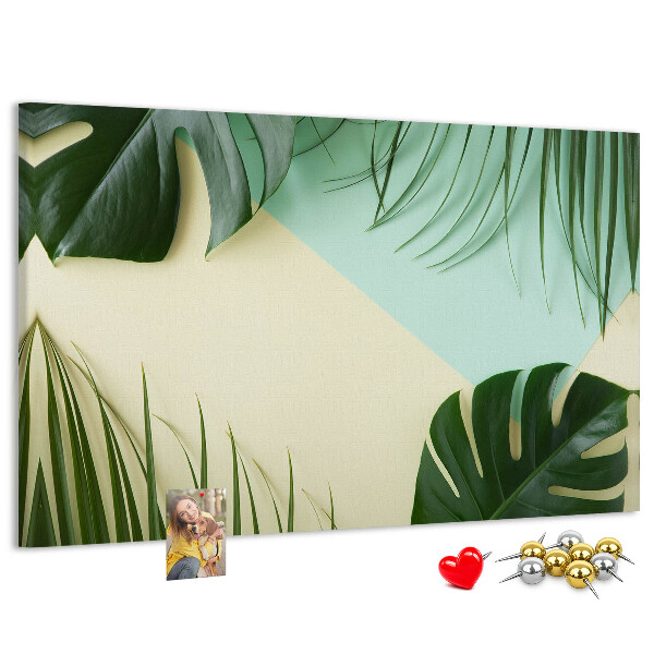 Tablero de corcho decorativo con diseño de hojas tropicales sobre fondo pastel