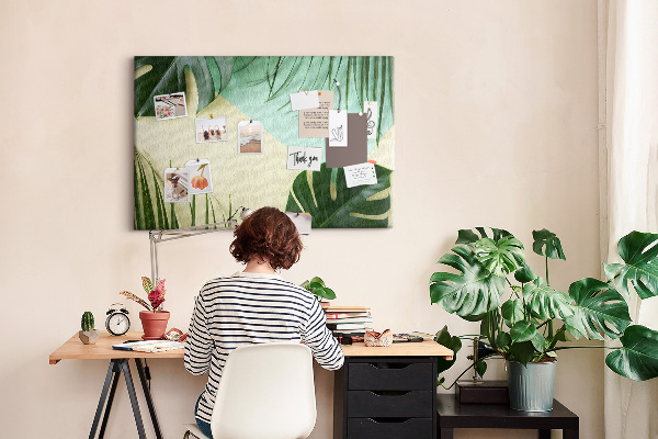 Tablero de corcho decorativo con diseño de hojas tropicales sobre fondo pastel
