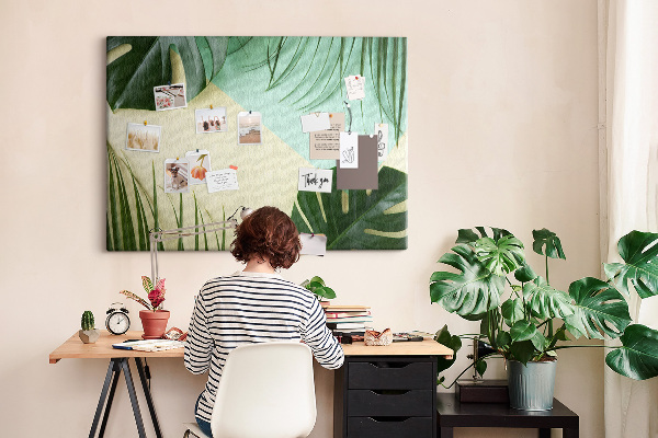 Tablero de corcho decorativo con diseño de hojas tropicales sobre fondo pastel