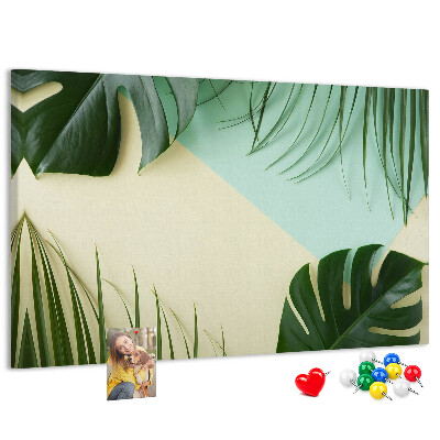 Tablero de corcho decorativo con diseño de hojas tropicales sobre fondo pastel