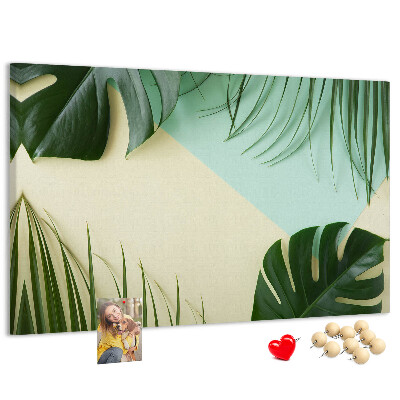 Tablero de corcho decorativo con diseño de hojas tropicales sobre fondo pastel