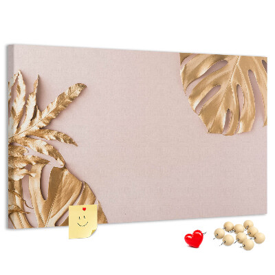 Pizarra de corcho con diseño de hojas doradas sobre fondo delicado