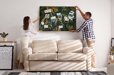 Tablero de corcho decorado con diseño de hojas doradas sobre fondo verde oscuro