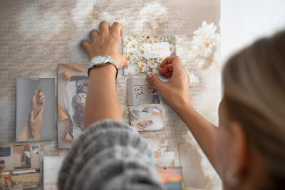 Tablero de corcho decorado con delicadas flores blancas sobre un fondo neutro