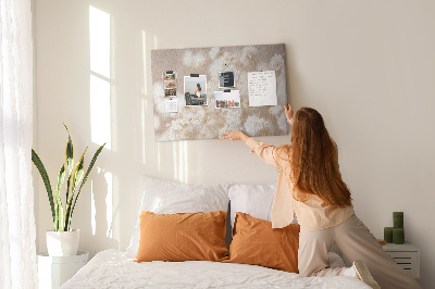 Tablero de corcho decorado con delicadas flores blancas sobre un fondo neutro