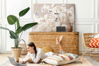Tablero de corcho decorado con delicadas flores blancas sobre un fondo neutro