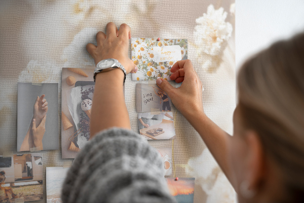 Tablero de corcho decorado con delicadas flores blancas sobre un fondo neutro