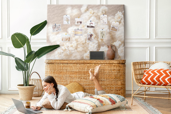 Tablero de corcho decorado con delicadas flores blancas sobre un fondo neutro