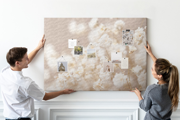 Tablero de corcho decorado con delicadas flores blancas sobre un fondo neutro