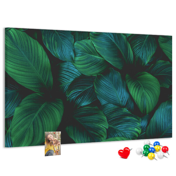 Pizarra de corcho con diseño de hojas tropicales sobre fondo oscuro