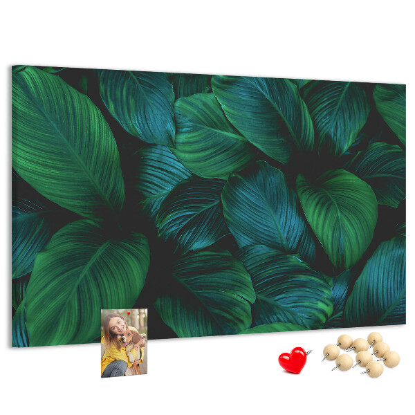 Pizarra de corcho con diseño de hojas tropicales sobre fondo oscuro