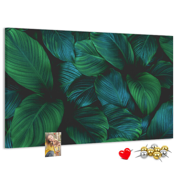 Pizarra de corcho con diseño de hojas tropicales sobre fondo oscuro